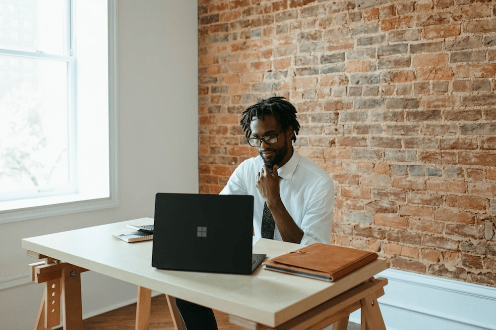 A man sitting at a table in front of a laptop